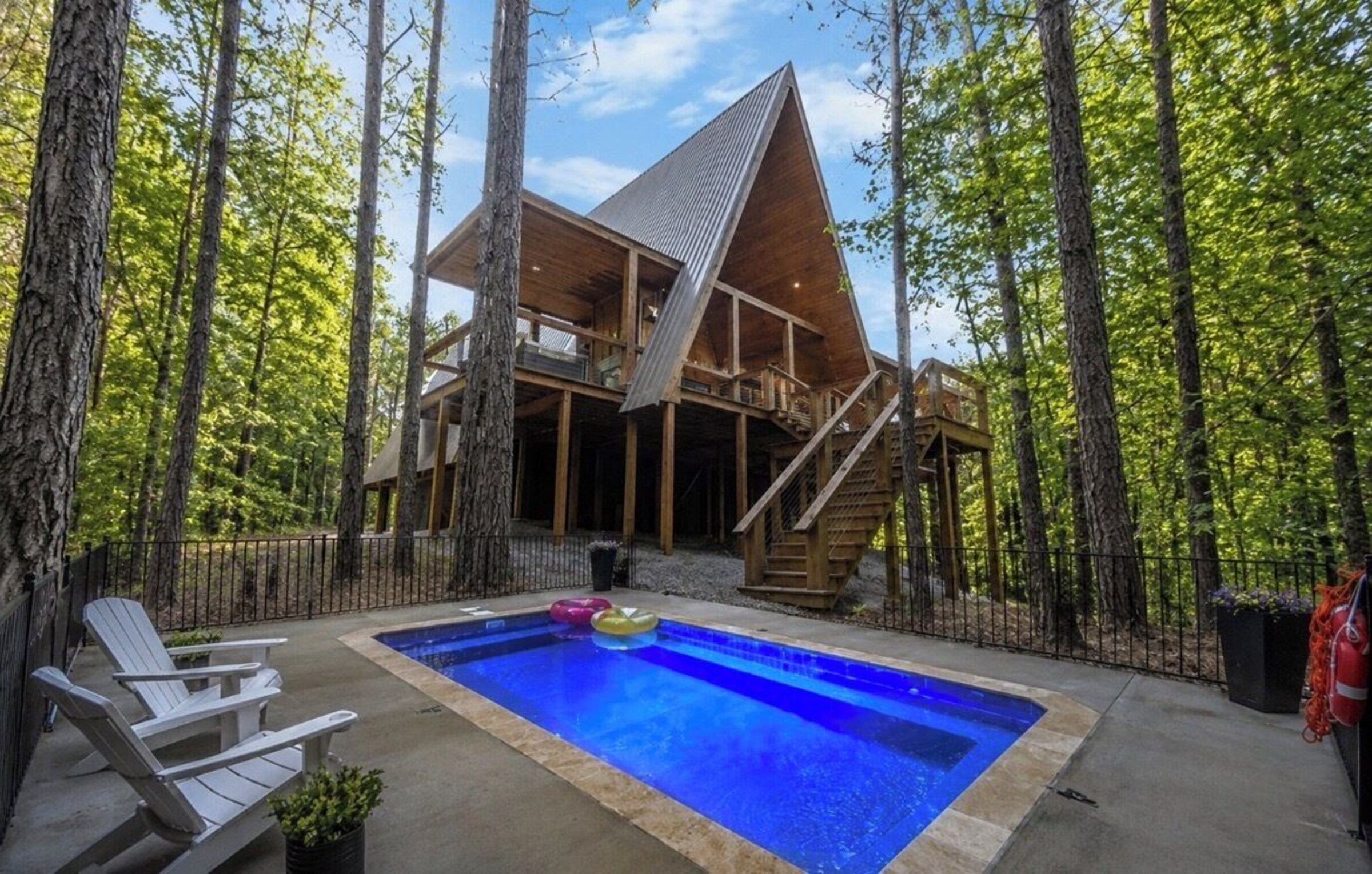 Private pool with Adirondack chairs beside the cabin